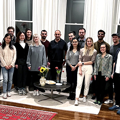 The members of the Munther Dahleh Research Group standing together, facing the camera, and smiling