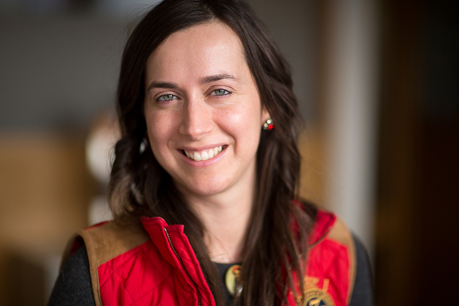 Fotini Christia smailes at camera in a red and brown quilted vest