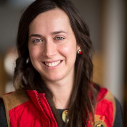 Fotini Christia smailes at camera in a red and brown quilted vest